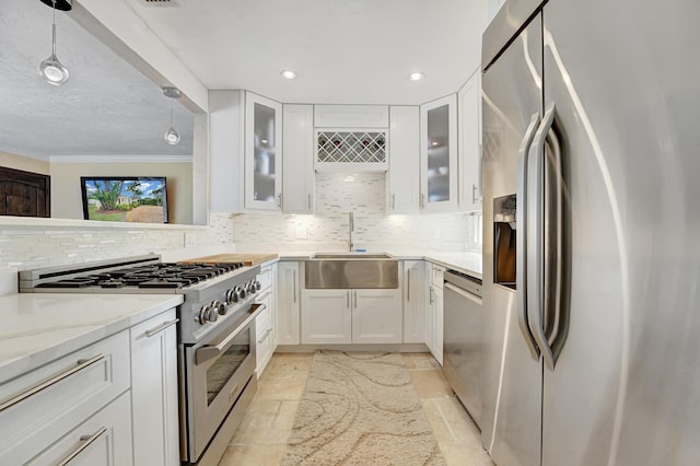 946 Paseo Morella, West Palm Beach, FL 33405 - kitchen with appliances with stainless steel finishes, a sink, decorative backsplash, white cabinetry, and crown molding
