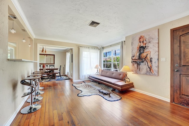 946 Paseo Morella, West Palm Beach, FL 33405 - living area featuring wood-type flooring, baseboards, a textured ceiling, and ornamental molding