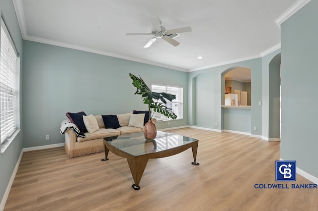 living area with ceiling fan, baseboards, ornamental molding, and wood finished floors