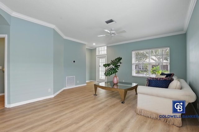 living room featuring crown molding, wood finished floors, and visible vents