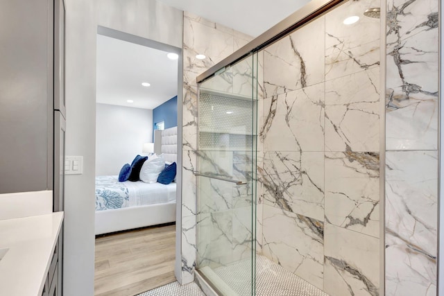 full bathroom featuring a marble finish shower, recessed lighting, ensuite bath, and wood finished floors