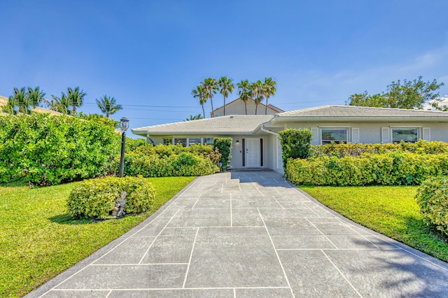 single story home with driveway, stucco siding, and a front lawn