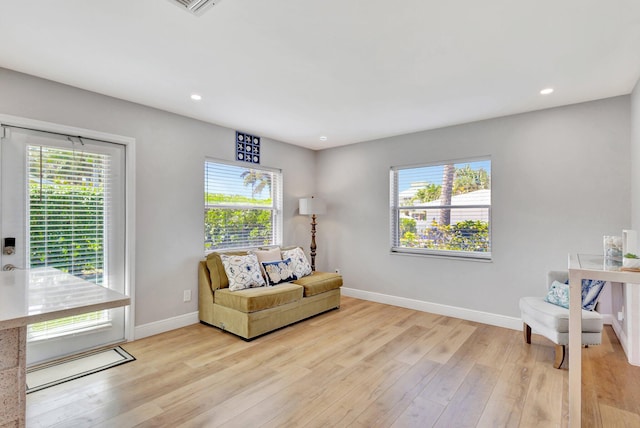 living area with light wood finished floors, baseboards, recessed lighting, and a wealth of natural light
