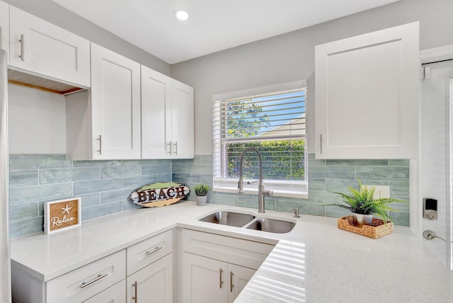 kitchen with a sink, decorative backsplash, white cabinetry, and recessed lighting