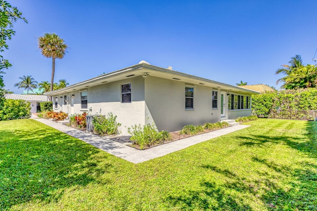 view of home's exterior featuring a yard, stucco siding, and fence