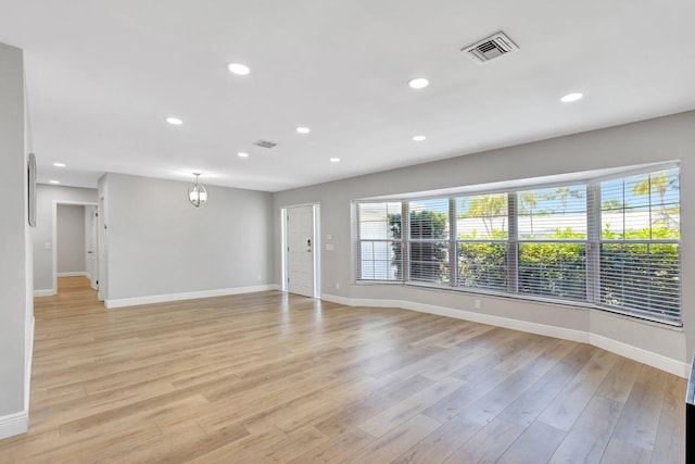 unfurnished living room with visible vents, baseboards, and light wood-style flooring