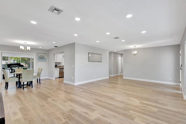 living room with visible vents, recessed lighting, light wood finished floors, baseboards, and a notable chandelier