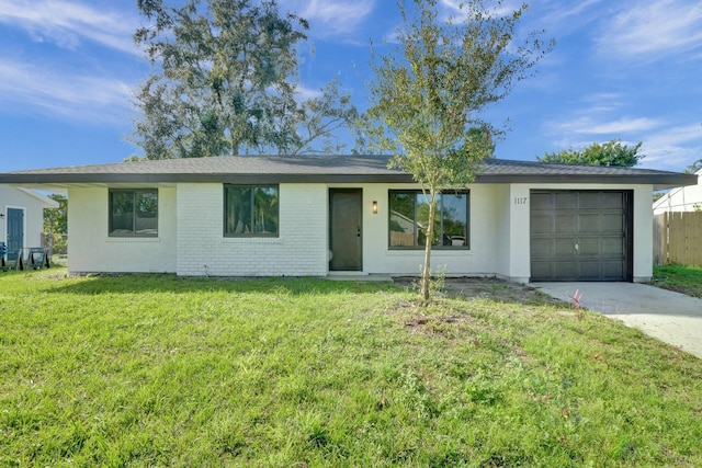 ranch-style house with an attached garage, concrete driveway, a front lawn, and brick siding