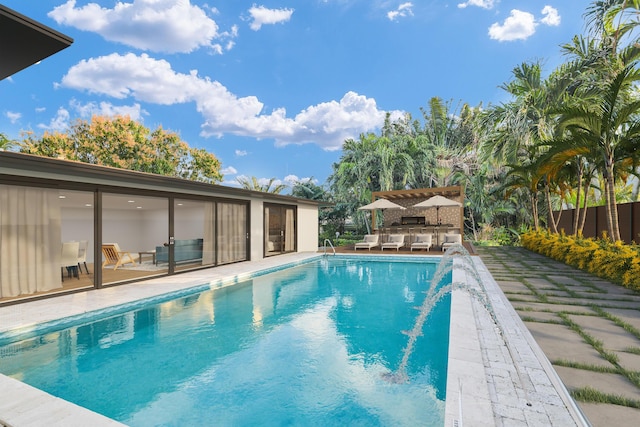 view of pool with outdoor dry bar, outdoor lounge area, a patio area, and a fenced in pool