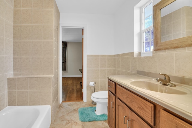 bathroom with tile walls, toilet, a washtub, tile patterned flooring, and vanity
