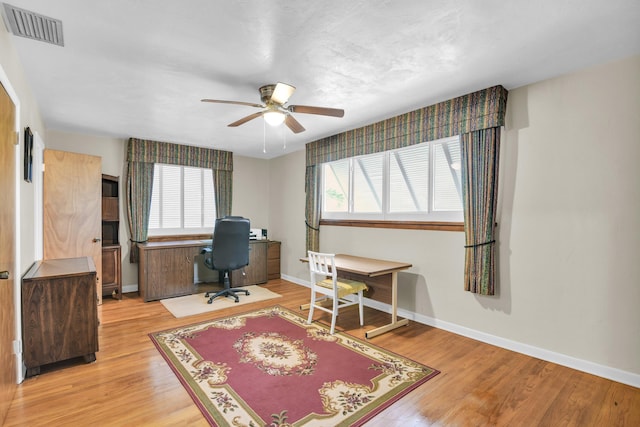 office area featuring ceiling fan, baseboards, visible vents, and light wood-style floors