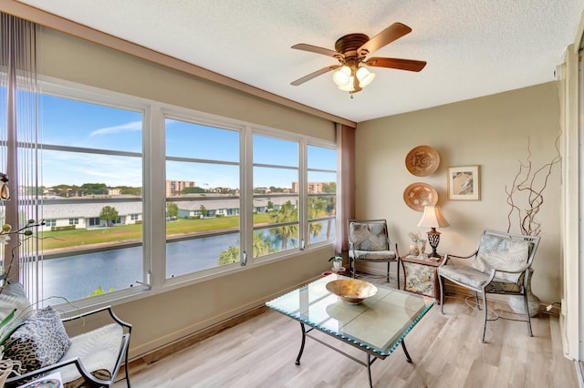 25 Abbey Ln Unit 404, Delray Beach, FL 33446 - sitting room with wood finished floors, a ceiling fan, a water view, a textured ceiling, and baseboards