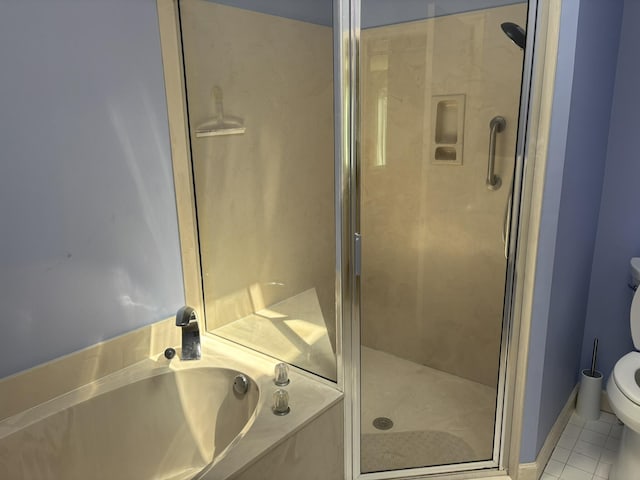 bathroom featuring tile patterned flooring, a shower stall, a garden tub, and toilet
