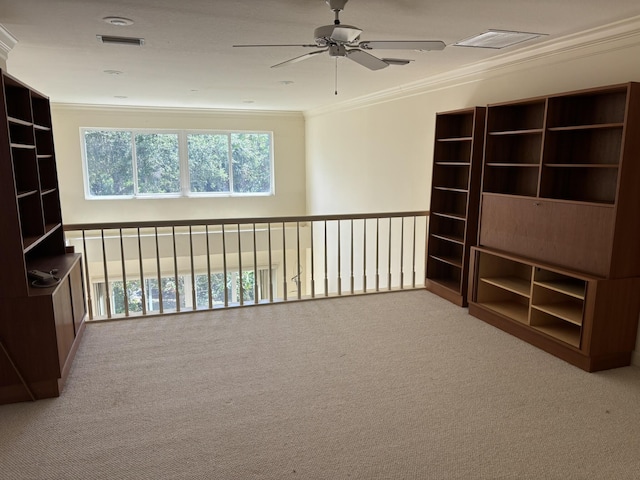 empty room with visible vents, carpet flooring, ceiling fan, and crown molding