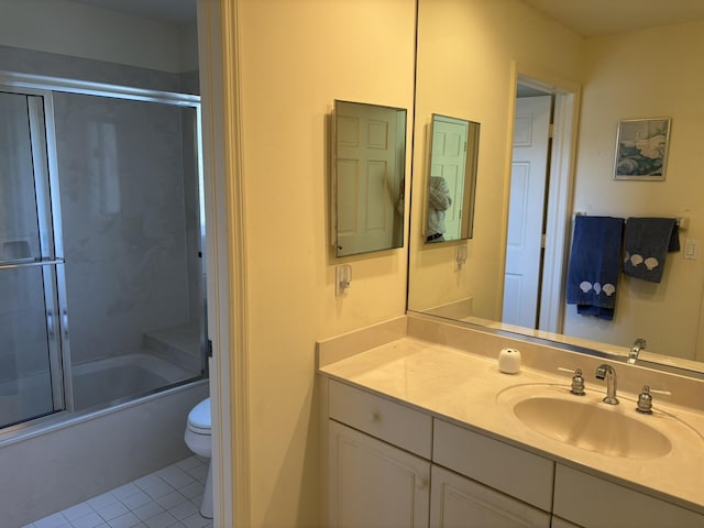 full bathroom featuring vanity, tile patterned flooring, bath / shower combo with glass door, and toilet