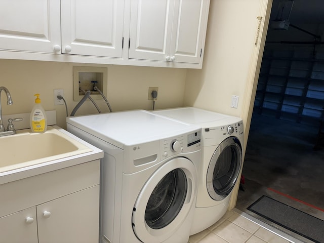 laundry area featuring separate washer and dryer, cabinet space, a sink, and light tile patterned flooring