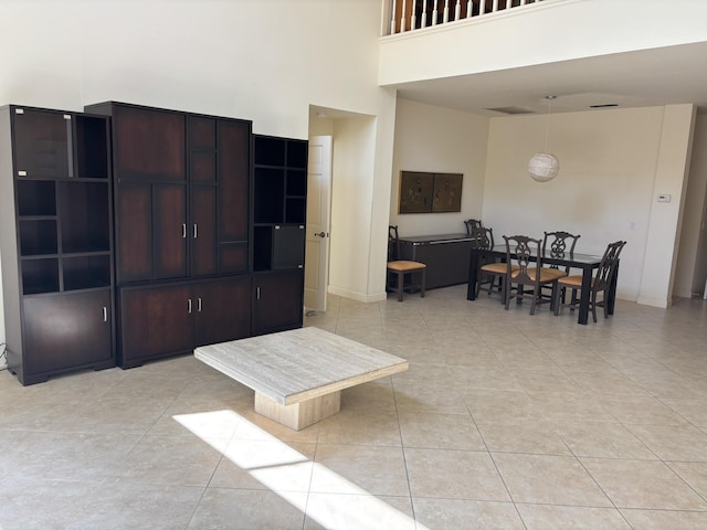 living room with light tile patterned flooring and a towering ceiling