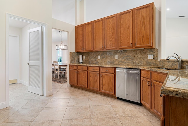 1167 Egret Cir S, Jupiter, FL 33458 - kitchen with dishwasher, brown cabinetry, backsplash, light stone countertops, and light tile patterned flooring