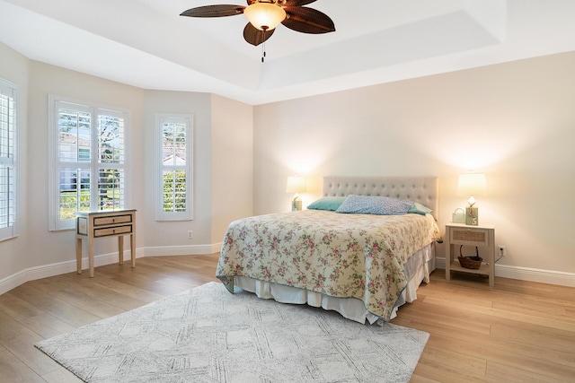 1167 Egret Cir S, Jupiter, FL 33458 - bedroom featuring light wood-style flooring, a raised ceiling, and a ceiling fan
