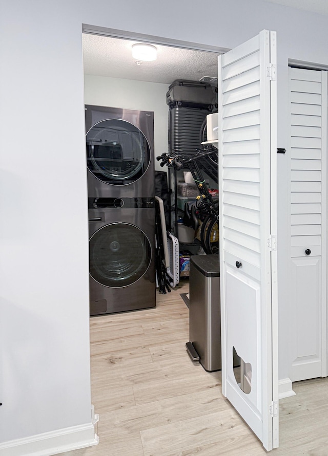 275 Murcia Dr Unit 304, Jupiter, FL 33458 - laundry area featuring stacked washing machine and dryer and light wood-style flooring