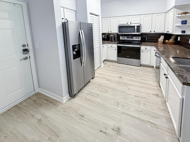 275 Murcia Dr Unit 304, Jupiter, FL 33458 - kitchen with stainless steel appliances, open shelves, light wood-style floors, and white cabinets