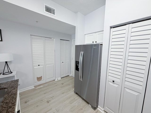 275 Murcia Dr Unit 304, Jupiter, FL 33458 - kitchen with stainless steel fridge, light wood-style floors, white cabinetry, dark stone countertops, and baseboards