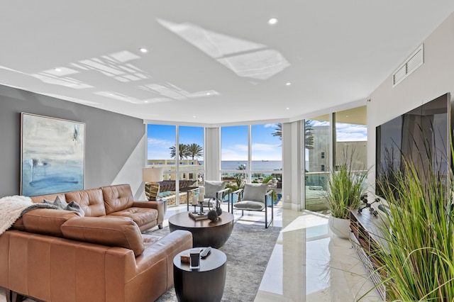 living room with expansive windows, visible vents, recessed lighting, and a water view