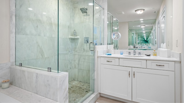 bathroom with vanity and a marble finish shower