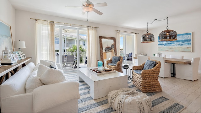 living area with light wood-type flooring and ceiling fan