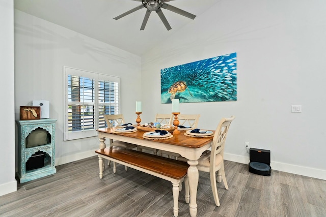 dining space featuring ceiling fan, high vaulted ceiling, wood finished floors, and baseboards