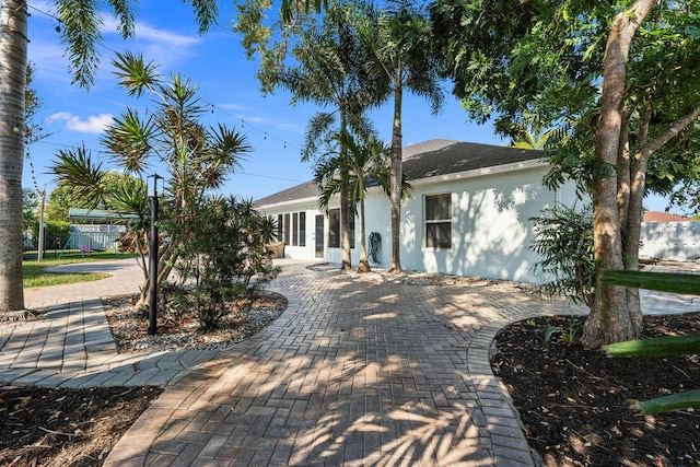 back of property with fence and stucco siding