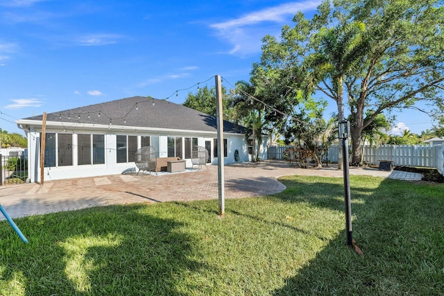 back of house with a patio area, a fenced backyard, a lawn, and roof with shingles
