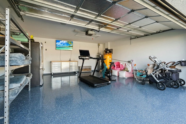 garage with a garage door opener and freestanding refrigerator