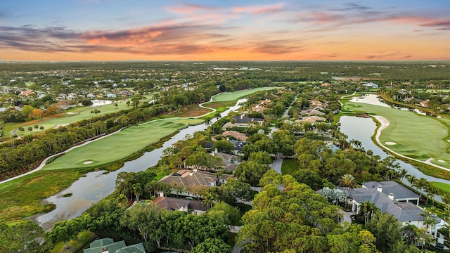aerial view at dusk with a residential view, view of golf course, and a water view