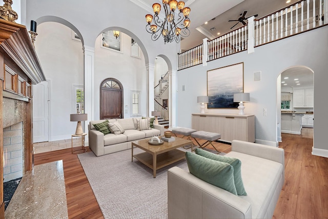 living area with a high ceiling, ceiling fan, and wood finished floors