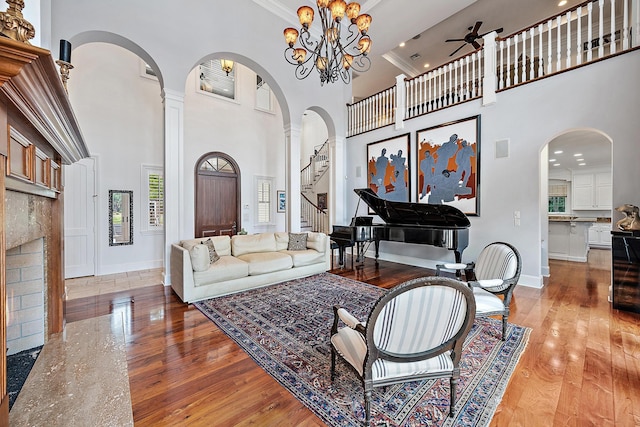 living area with a ceiling fan, baseboards, and a towering ceiling