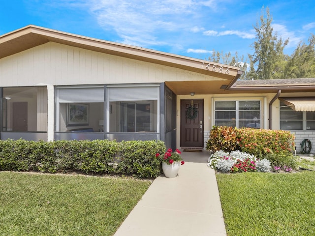 14586 Lucy Dr, Delray Beach, FL 33484 - view of exterior entry featuring a lawn