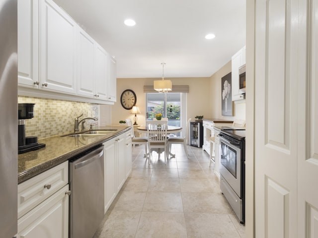 14586 Lucy Dr, Delray Beach, FL 33484 - kitchen with a sink, dark stone counters, white cabinetry, backsplash, and appliances with stainless steel finishes