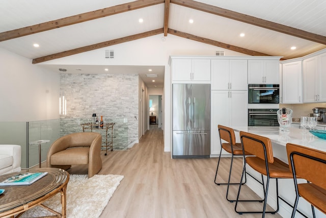 kitchen with built in refrigerator, white cabinetry, light wood finished floors, and visible vents