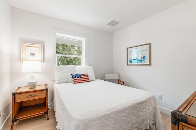 bedroom featuring light wood finished floors, baseboards, and visible vents