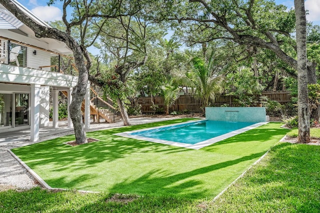 view of pool featuring stairway, a fenced backyard, a yard, and a patio