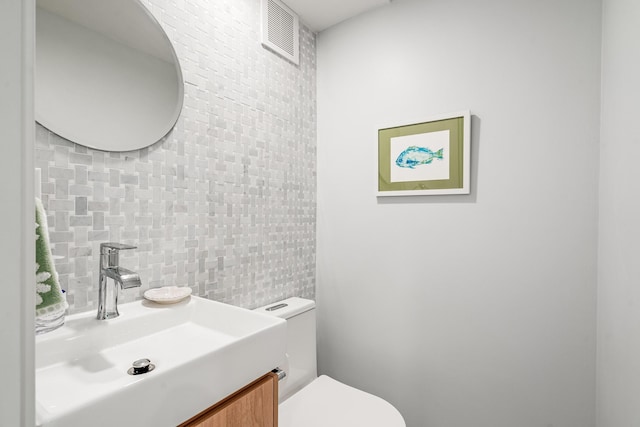 bathroom featuring visible vents, toilet, and vanity