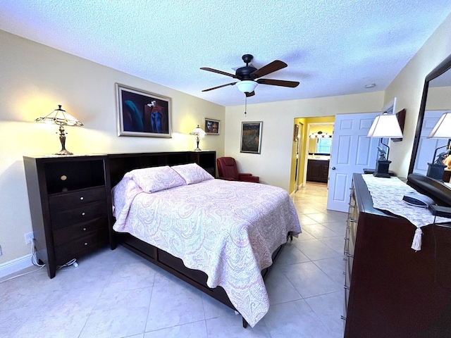 4330 Lucerne Villas Ln, Lake Worth, FL 33467 - bedroom featuring a ceiling fan, a textured ceiling, light tile patterned floors, baseboards, and connected bathroom