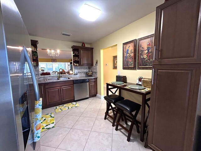 4330 Lucerne Villas Ln, Lake Worth, FL 33467 - kitchen with visible vents, dark brown cabinetry, light tile patterned flooring, a sink, and appliances with stainless steel finishes