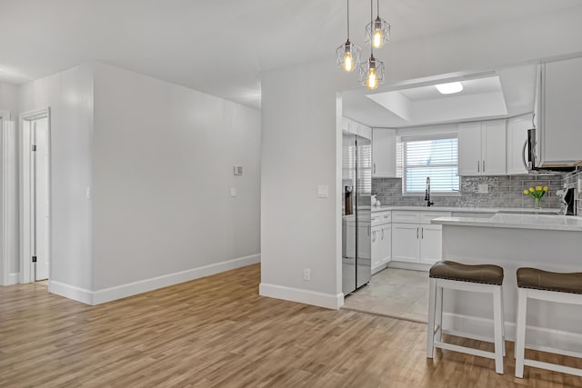 2894 Crosley Dr E Unit G, West Palm Beach, FL 33415 - kitchen with a kitchen breakfast bar, tasteful backsplash, light wood-style flooring, stainless steel appliances, and light countertops