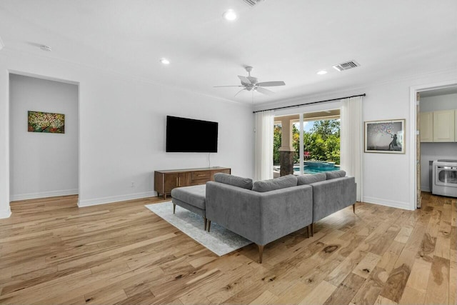 living room featuring baseboards, visible vents, ornamental molding, and light wood-style flooring