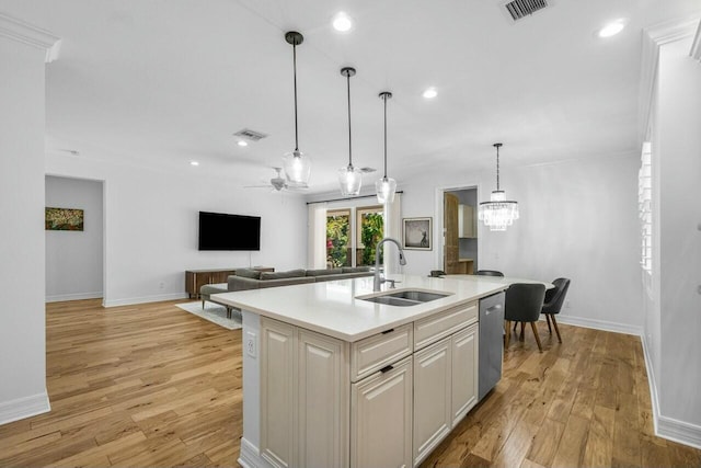 kitchen with stainless steel dishwasher, light countertops, a sink, baseboards, and visible vents
