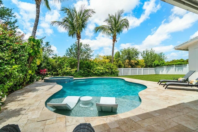 view of swimming pool featuring a pool with connected hot tub, a patio, and a fenced backyard