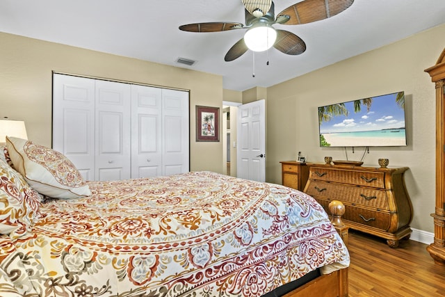 bedroom featuring a ceiling fan, a closet, wood finished floors, and visible vents