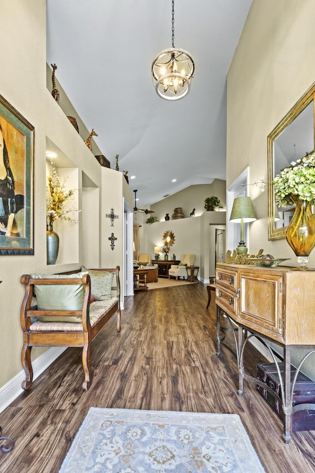 entrance foyer featuring an inviting chandelier, baseboards, vaulted ceiling, and wood finished floors